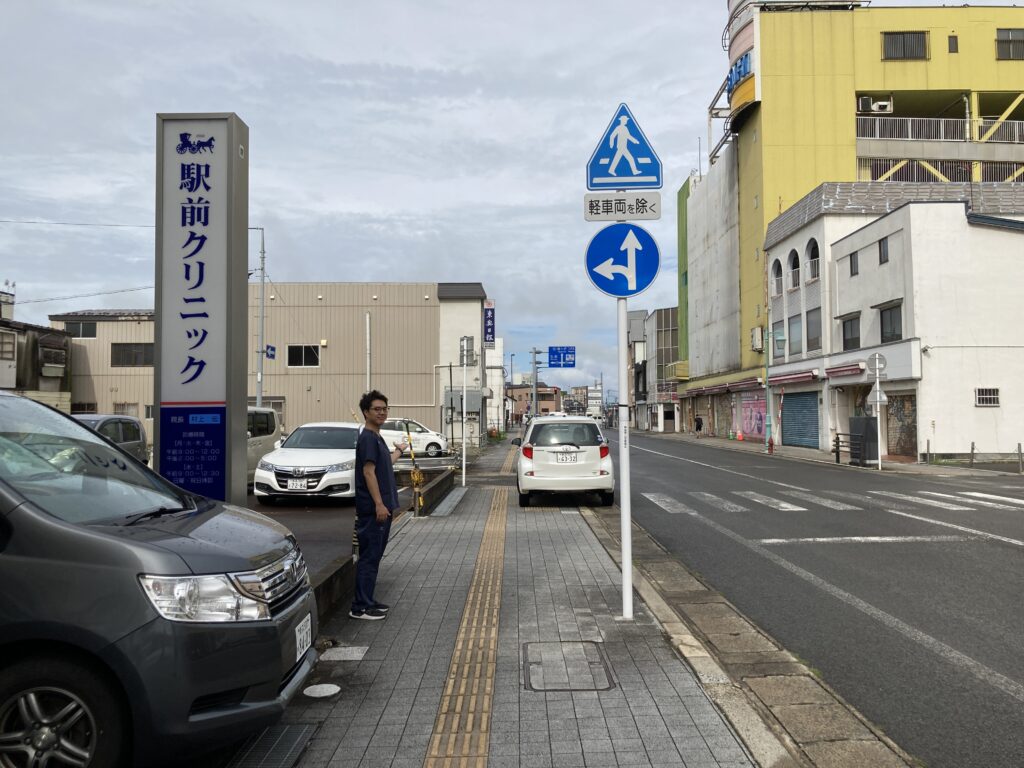 駅前クリニックさんの前で道案内する院長村田の写真